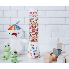 two stuffed animals sitting next to each other in front of a tall tube filled with candy