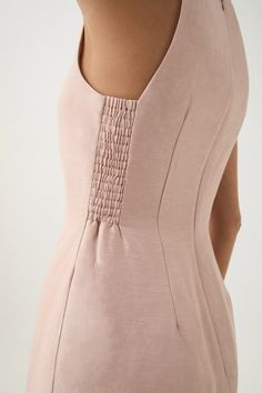 the back of a woman's body wearing a pink dress