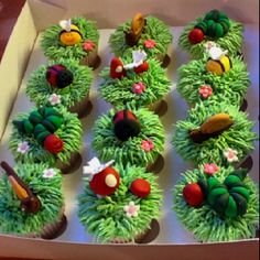 cupcakes are decorated with green frosting and colorful decorations on top of grass