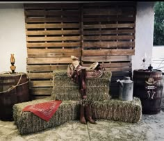 hay bales stacked on top of each other in front of a wall with wooden slats