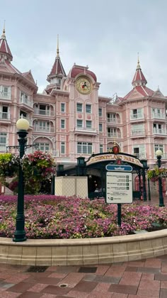 a large pink building with lots of flowers around it