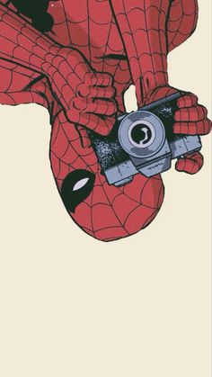 the spider - man is holding a camera in his hands