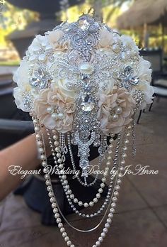 the bridal bouquet is adorned with pearls and crystal beads, as well as flowers