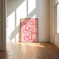 a pink painting sitting on top of a hard wood floor