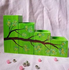 three pieces of green painted wood sitting on top of a white sheet with pink balls