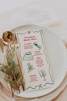 a christmas menu on a plate with gold utensils