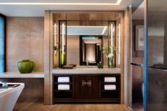 a bathroom with a tub, sink and large mirror in the middle of it's wall