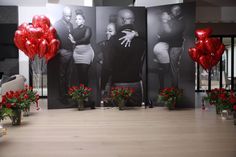 two large black and white pictures with red balloons in front of them on the wall