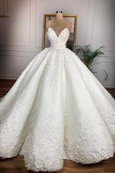 a white wedding dress on display in front of a mirror