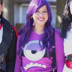 three people dressed up in costumes standing next to each other and smiling at the camera