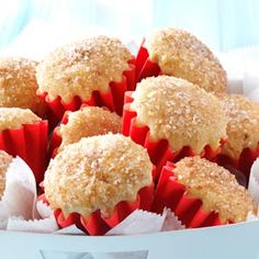 a box filled with muffins covered in powdered sugar on top of a blue table