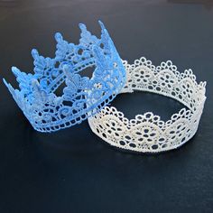 two white and blue tiaras sitting on top of a table