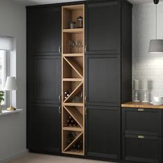 a wine rack in the corner of a kitchen with dark wood cabinets and black cupboards