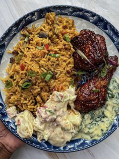 a blue and white plate topped with meat, rice and veggie covered entree