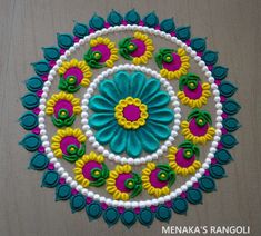 a colorful circular design with flowers and leaves in the center on a wooden table top