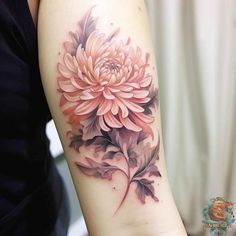 a woman's arm with a pink flower tattoo on the left side of her arm