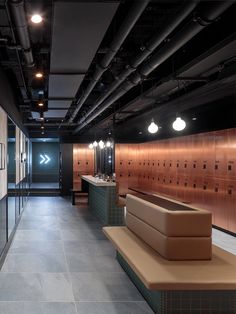 an empty public restroom with benches and lockers