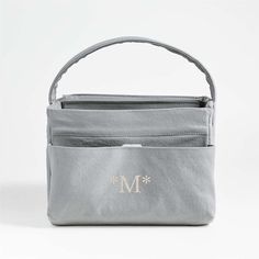 a gray bag with the letter m in gold on it and a monogrammed handle