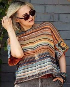 a woman wearing sunglasses and a multicolored sweater