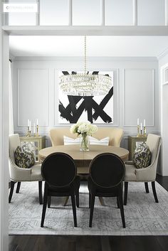 a dining room table with chairs and a chandelier hanging from the ceiling above it