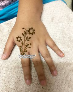 a child's hand with a hendi on it and flowers painted on the palm