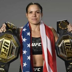 the woman is holding two wrestling belts in her hands and an american flag scarf around her neck