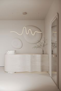 a white room with a circular light fixture above the counter