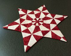 a red and white quilted star sitting on top of a table