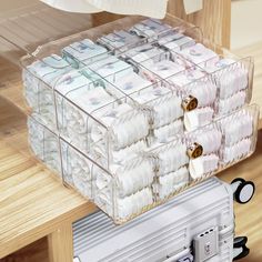 a stack of baby diapers sitting on top of a wooden table next to a suitcase