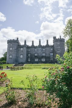 an old castle sitting on top of a lush green field