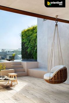 a hanging chair in the middle of a room with an open floor to ceiling window