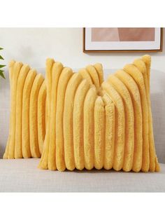 two yellow pillows sitting on top of a couch