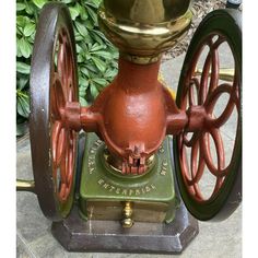 an old fashioned fire hydrant sitting on top of a cement ground next to green plants