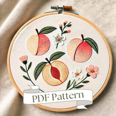 an embroidery project with peaches and flowers on it's hoop frame that says pdf pattern