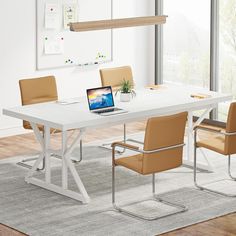 a white table with four chairs and a laptop on it in front of a window