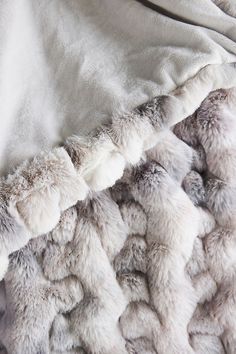 a blanket with white and grey fur on it