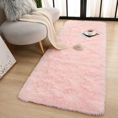 a pink rug on the floor with a chair and window in the backgroud