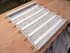 a wooden table topped with construction materials on top of it's sides and covered in plastic sheeting