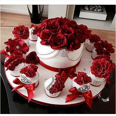 a wedding cake with red roses on top