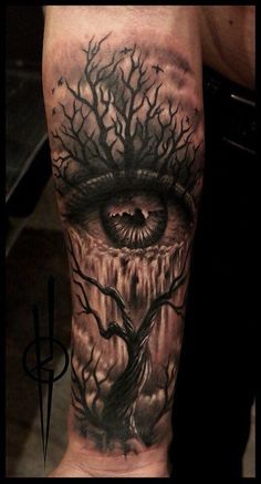 a man's leg with an eye and tree on it