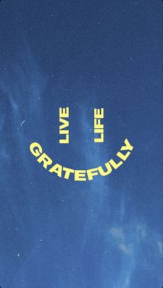 the words live, love and grateful written in yellow on a blue sky with clouds