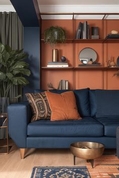 a living room with blue couches and wooden shelves on the wall above them is a coffee table