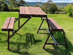 a picnic table with two benches in the grass