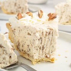 a piece of cake on a plate with a fork next to it and another slice in the background