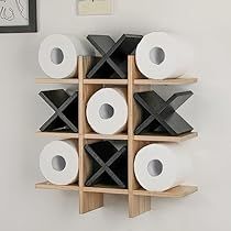 several rolls of toilet paper are stacked on wooden shelves next to a wall with pictures