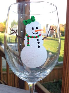 a wine glass with a snowman painted on it