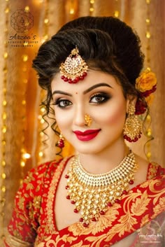 a woman in red and gold outfit with jewelry on her head, posing for the camera