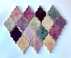 an assortment of different colored glass tiles on a white surface, arranged in the shape of a heart