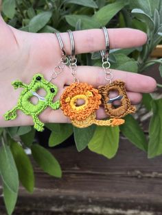 two crocheted key chains are being held by a hand