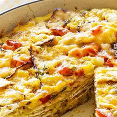 an omelet in a pan with one slice cut out and ready to be eaten